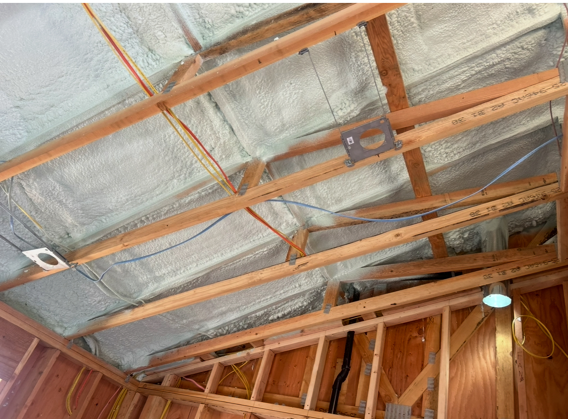 Freshly installed attic insulation between wood rafters